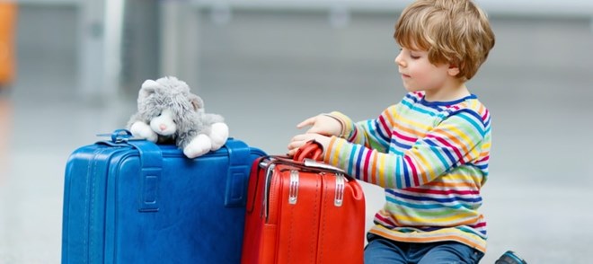הילד עצוב וממתין עם המזוודות - יאלץ להפרד מאחד מהוריו